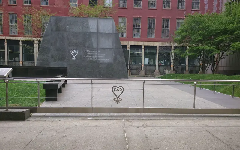 Outdoor memorial entrance with closed gate.