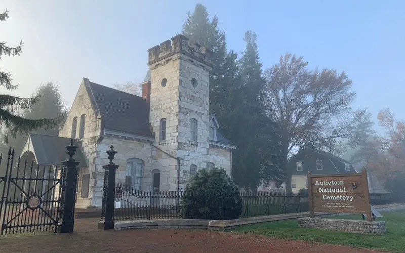 stone building with black fence in foreground