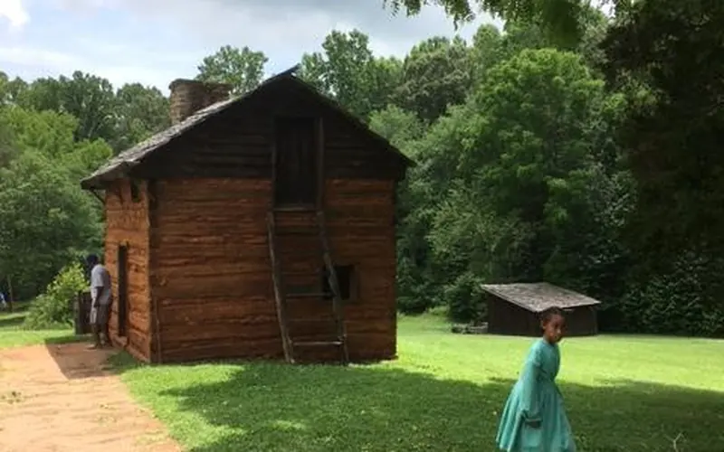 Kitchen cabin with child in green dress in front