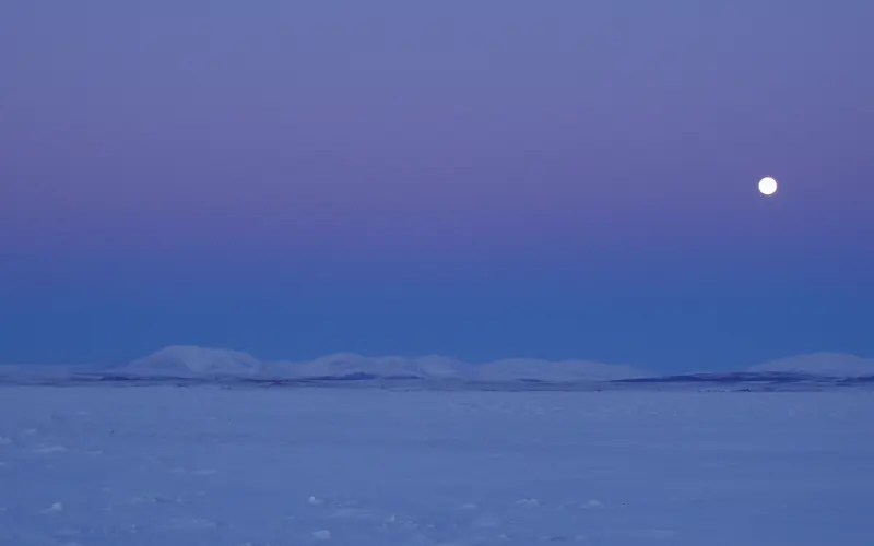 moon over snow covered hills