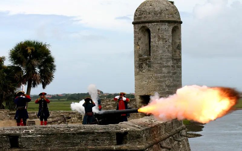 Re-enactors of the first Spanish period cover their ears while firing a cannon.