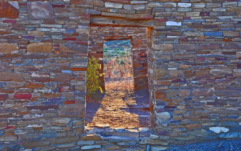 Colorful sandstone walls with two open sections in the middle that look like doorways.