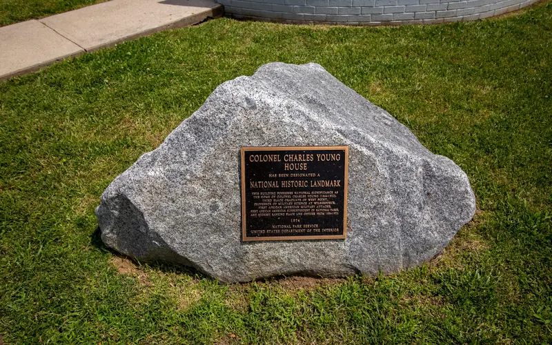 A large gray stone boulder with a bronze plaque on it indicating a national historical landmark