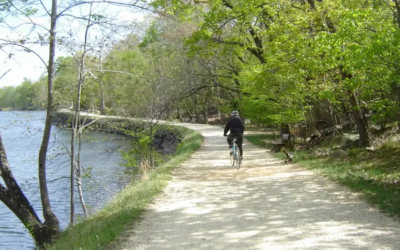 A single bike rider on the towpath next to the widewater section of the canal.