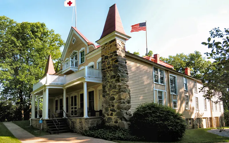 side view of Clara Barton's house with Red Cross flag and American Flag.