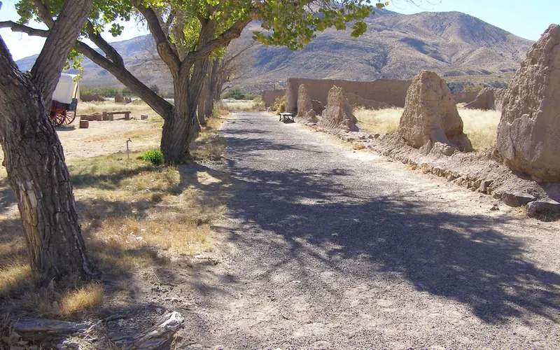 fort ruins in the sunlight with cottonwood trees on the left