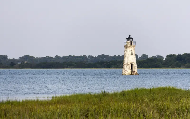 The white masonry Cockspur Island lighthouse sits in the Savannah River.