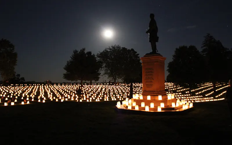 Monument in national cemetery illuminated by candles