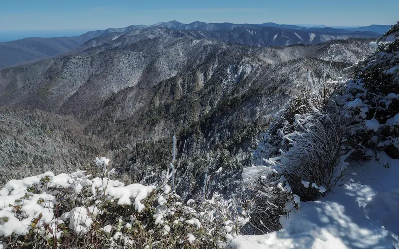 A clear sky with a vast snowy mountain scene.