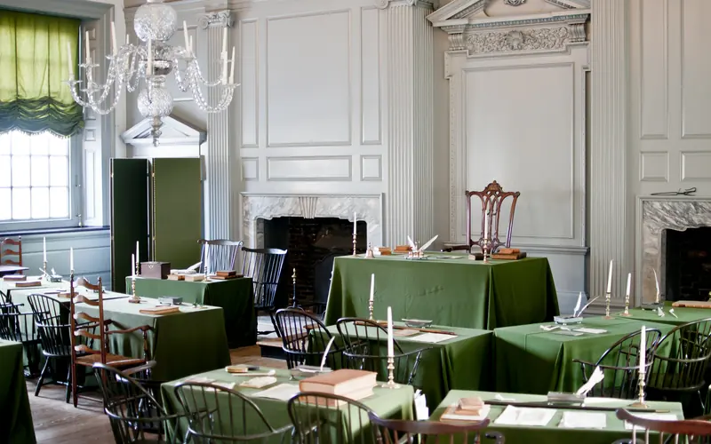 A color photo of the Assembly Room showing 18th century chairs and green, cloth covered tables