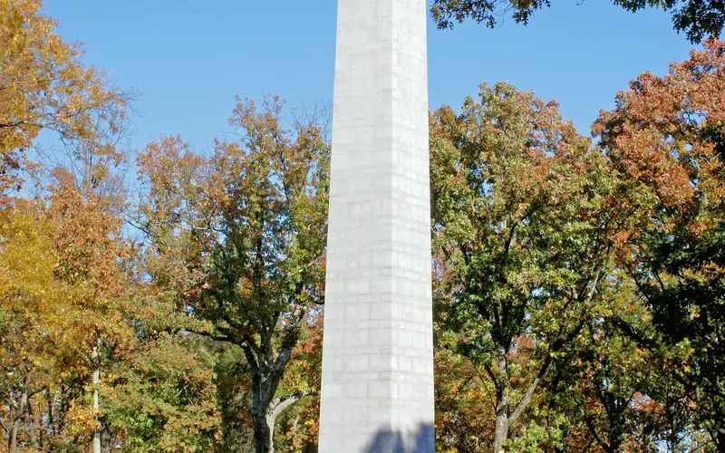 The US Monument is surrounded by trees that are turning orange and yellow.