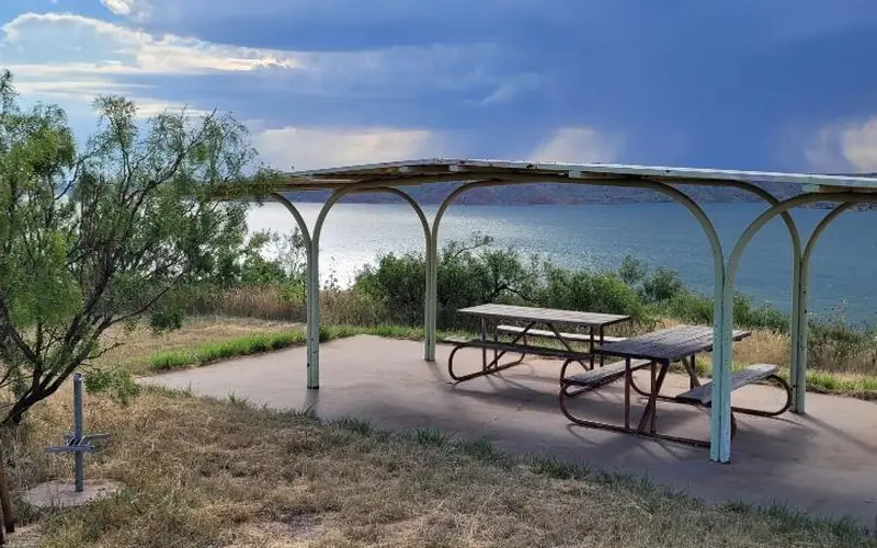 Picnic shelter at a campsite overlooking Lake Meredith.  The sky is blue with no clouds.