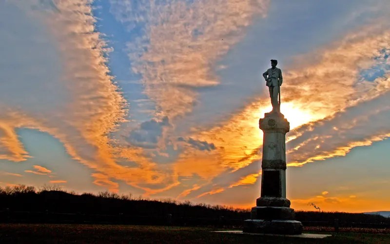 The sun setting behind a monument.