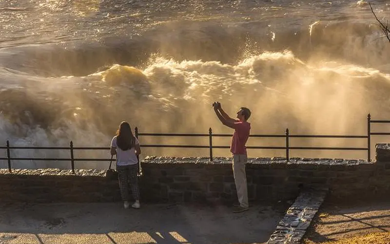 Man overlooking the falls while taking a selfie