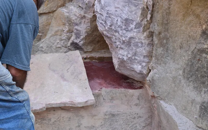A sheet of stone being taken off a thick slab of stone in a quarry pit