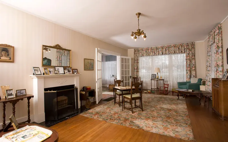 A view of the living room with a fireplace, rug, recliner and other furniture