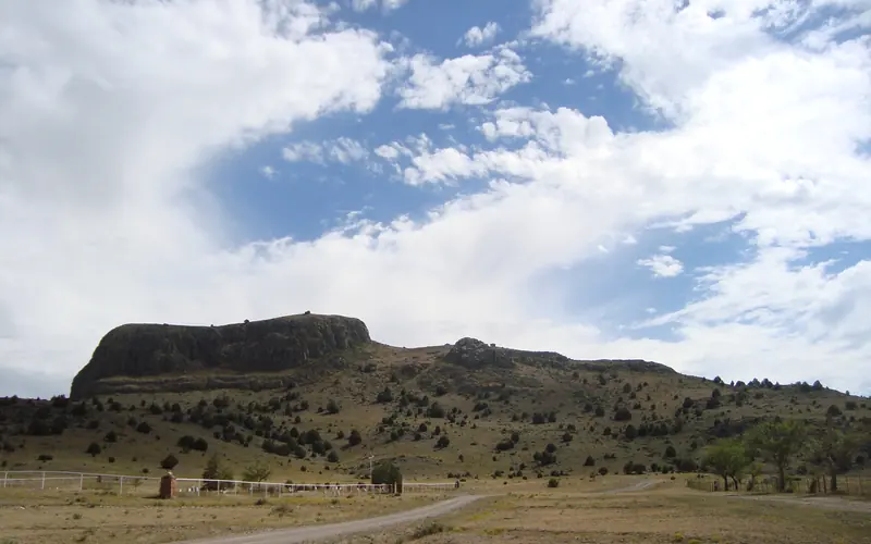 desert landscape with a mountain that looks like a wagon from a distance, verdant green grasses