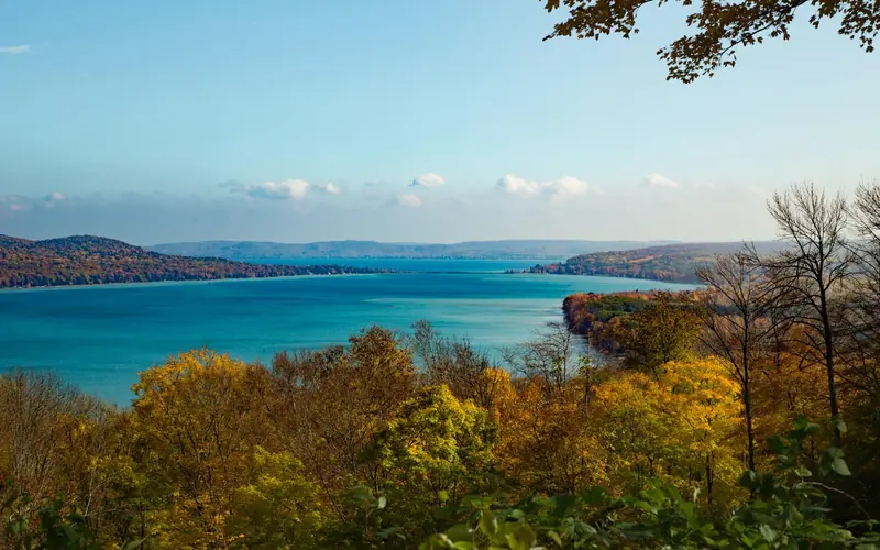 An overlook of two blue lakes surrounded by trees with fall leaves