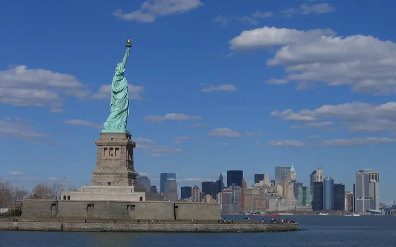 The Statue of Liberty in front of the New York City skyline.
