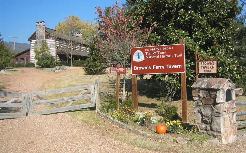 structure in the background with large chimney on the end; signs saying Brown's Ferry Tavern