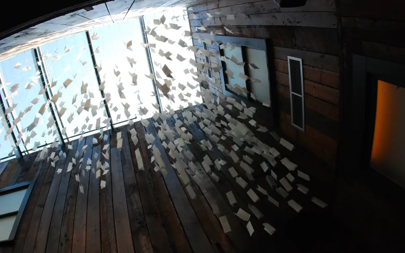 a mobile of letters written on white paper hangs in the museum lobby