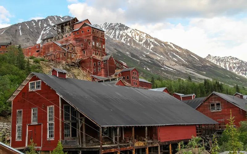 Historic, large, red buildings with mountains in the background