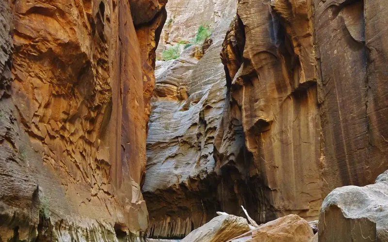 Tall, red, sandstone walls enclose a narrow river.